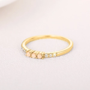 Makroaufnahme minimalistischer Goldring mit drei rosa Opalperlen und Seitenkristallen