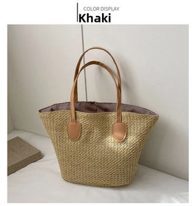 Detail showing khaki straw woven texture and brown leather strap on beach tote bag