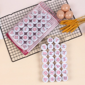 Detail of pink and white alphabet cookie stamps in professional baking scene setup