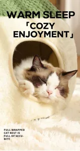 Primo piano di un gatto che dorme nella cuccia a grotta di peluche con scritta WARM SLEEP