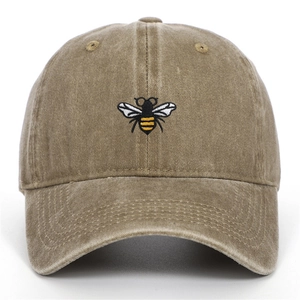 Gros plan d'une casquette en coton délavé avec une broderie d'abeille détaillée