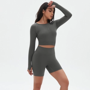 Detail von grauem Langarm-Crop-Top mit Daumenlöchern und hoch taillierten Biker-Shorts