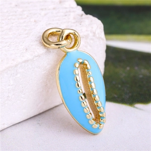 Macro shot of sky blue enamel conch shell pendant with gold plating and hanging ring