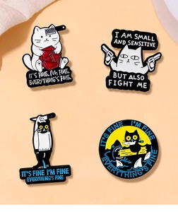 Detail of four funny cat enamel pins with humorous text on a light pink background