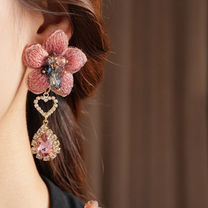 Détail de la boucle d'oreille fleur brodée rose avec cœur et goutte en cristal