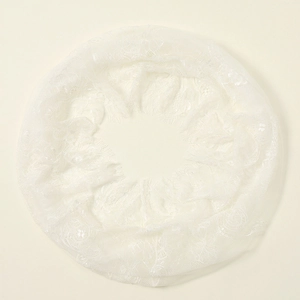Close-up of white lace circular veil showing fine floral mesh texture on beige background