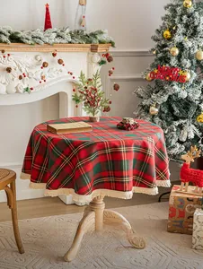 Classic red and green plaid round tablecloth with cream fringe in a festive holiday setting