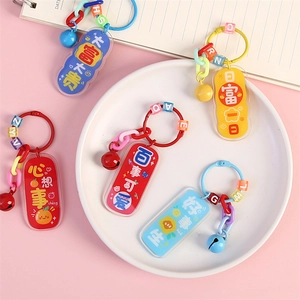 Creative acrylic inspirational keychains with colorful beads and small bells on a pink backdrop