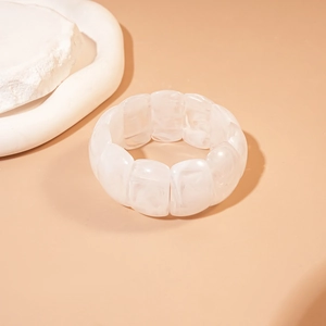 Detail of white marble textured acrylic stretch bracelet with geometric resin tiles