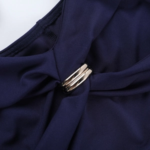 Close-up of elegant dark blue dress fabric featuring a decorative gold metal ring detail