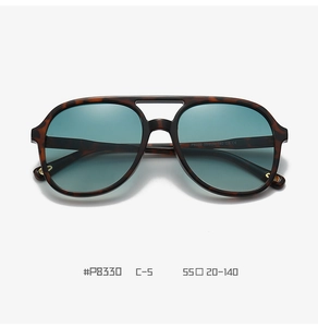 Close-up of retro aviator sunglasses with tortoise shell frame and green TAC lenses