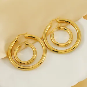 Polished 18K gold-plated titanium steel hollow hoop earrings on elegant silk background