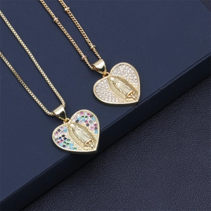 Detailed macro of gold heart pendants with Mary relief and colorful zircon inlay