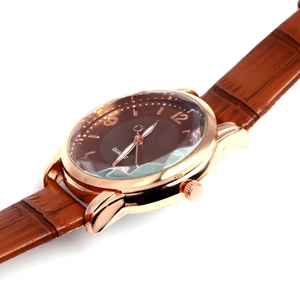 Detail view of quartz watch with rose gold case, brown leather strap, and dark numbered dial