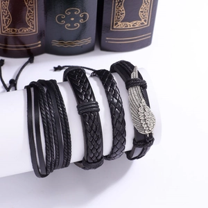 Détail d'un ensemble de 4 bracelets en cuir tressé noir avec breloque aile argentée
