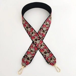 Detail of floral jacquard embroidery on thick wide strap with golden metal hooks