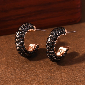 Rose gold geometric C-shaped earrings with black crystals in elegant studio lighting