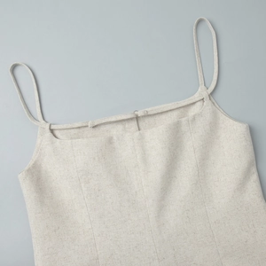 Detailed close-up of cream linen tank top with thin spaghetti straps and square neckline