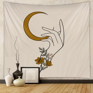 Detail of bohemian wall tapestry with hand and moon motif on minimalist fabric