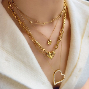 Close-up of gold layered heart necklaces with sparkling rhinestones on model