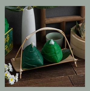 Detailed view of green zongzi-shaped candles with bamboo tray for Dragon Boat Festival