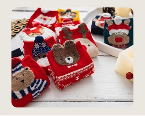 Detailed macro of stacked Christmas knit socks featuring reindeer and Santa patterns