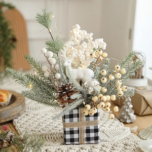 Christmas pine needle box with berries, cones and LED lights on a beige knit mat