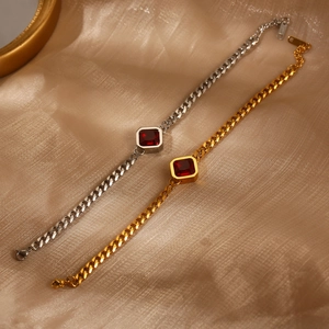Detailansicht goldener und silberner Panzerarmbänder mit roten quadratischen Zirkonia