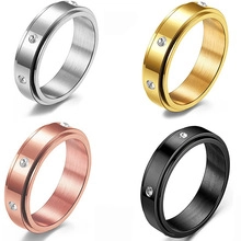 Polished stainless steel rings in four colors with small inlaid zircon stones on white
