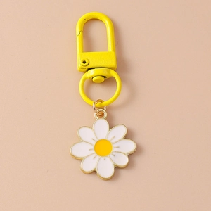 Detail of yellow metal lobster clasp with white and yellow daisy flower pendant keychain