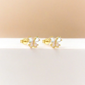 Macro view of gold S925 silver butterfly studs with pink teardrop gemstones