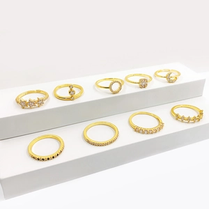 Set of 9 gold metal rings featuring stars, moons, and rhinestones on white stands