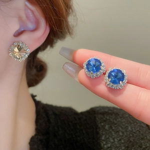 Nahaufnahme funkelnder geometrischer Ohrringe mit champagner- und blauen Kristallen