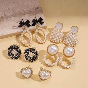 Detailed set of elegant gold and black earrings with pearls, bows and floral designs