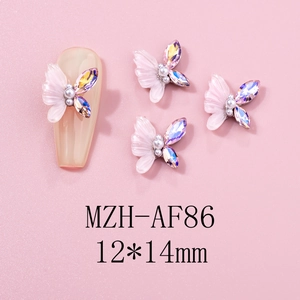 Macro detail of 12x14mm pink resin butterfly nail charm with center pearl and crystals