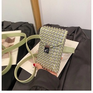 Close-up of light green crossbody bag with sparkling rhinestones and silver lock