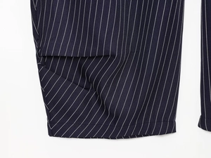 Detail der Seitentaschen und weißen vertikalen Streifen auf marineblauer Leinenhose