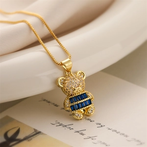 Macro detail of gold-plated teddy bear pendant with sparkling blue and white crystals