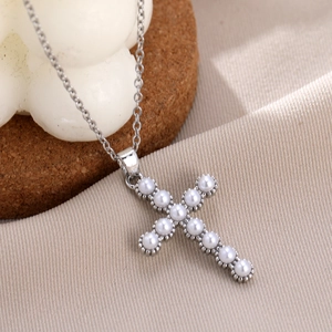 Macro view of cross pendant necklace with micro-set zircons and white pearls