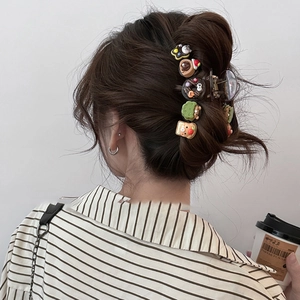 Cartoon bear donut hair claw clip made of dark translucent resin worn by a model
