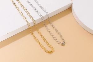 Detailed view of faceted oval link necklaces in gold and silver finish with lobster clasp