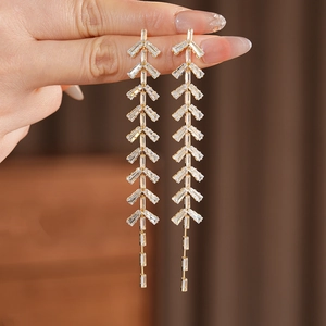 Macro shot of long fringe drop earrings with gold plating and baguette-cut zircons