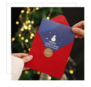 Close-up of 3D Christmas card set with red envelope and festive golden seal sticker