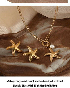 Detail of starfish pendant necklace with pearl on marble tray, waterproof gold jewelry set