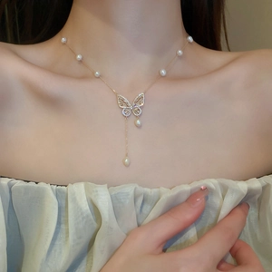 Detailed view of a gold butterfly necklace with zircon stones and freshwater pearls