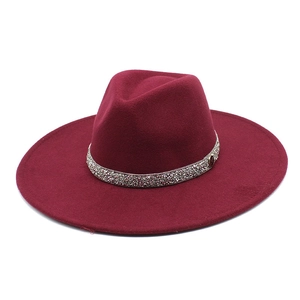 Detail of burgundy wool fedora with sparkling rhinestone band on white background
