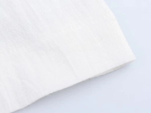 Vue détaillée du tricot de coton blanc et de l'ourlet piqué d'un blazer décontracté