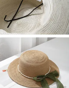 Detail view of woven straw hat featuring adjustable drawstring and elegant pearl accents