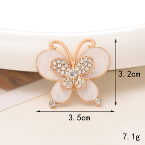 Macro shot of butterfly accessory with white crystals showing 3.5cm width and 3.2cm height
