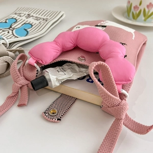 Dettaglio borsa rosa in maglia con manico a nuvola imbottito e chiusura con bottone